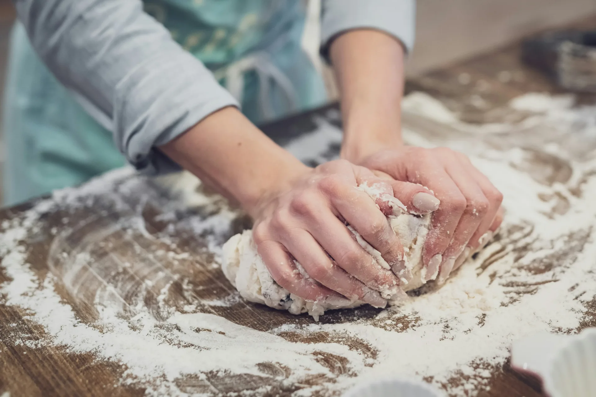 Baker kneading dough in the bakery kitchen