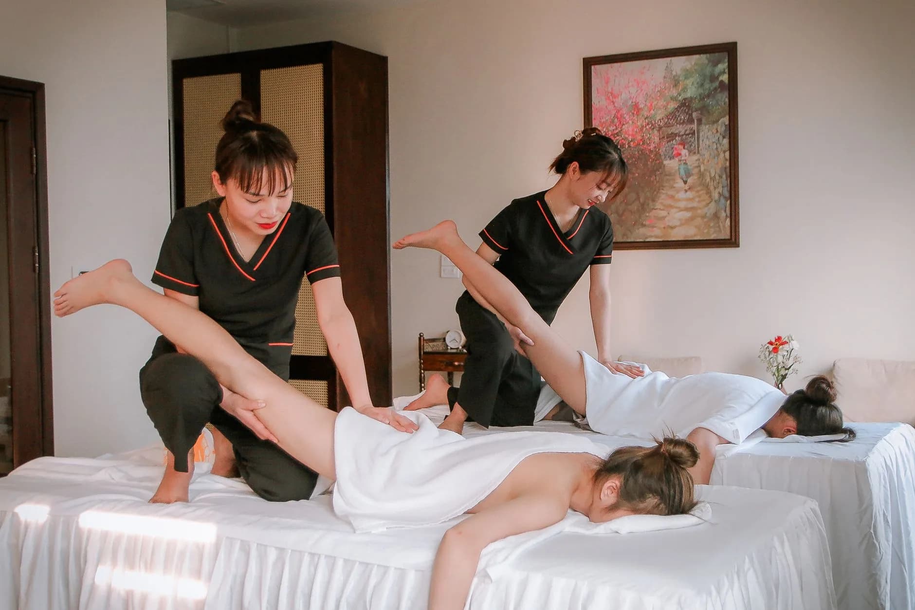 A spa therapist preparing a treatment room with calm, professional care
