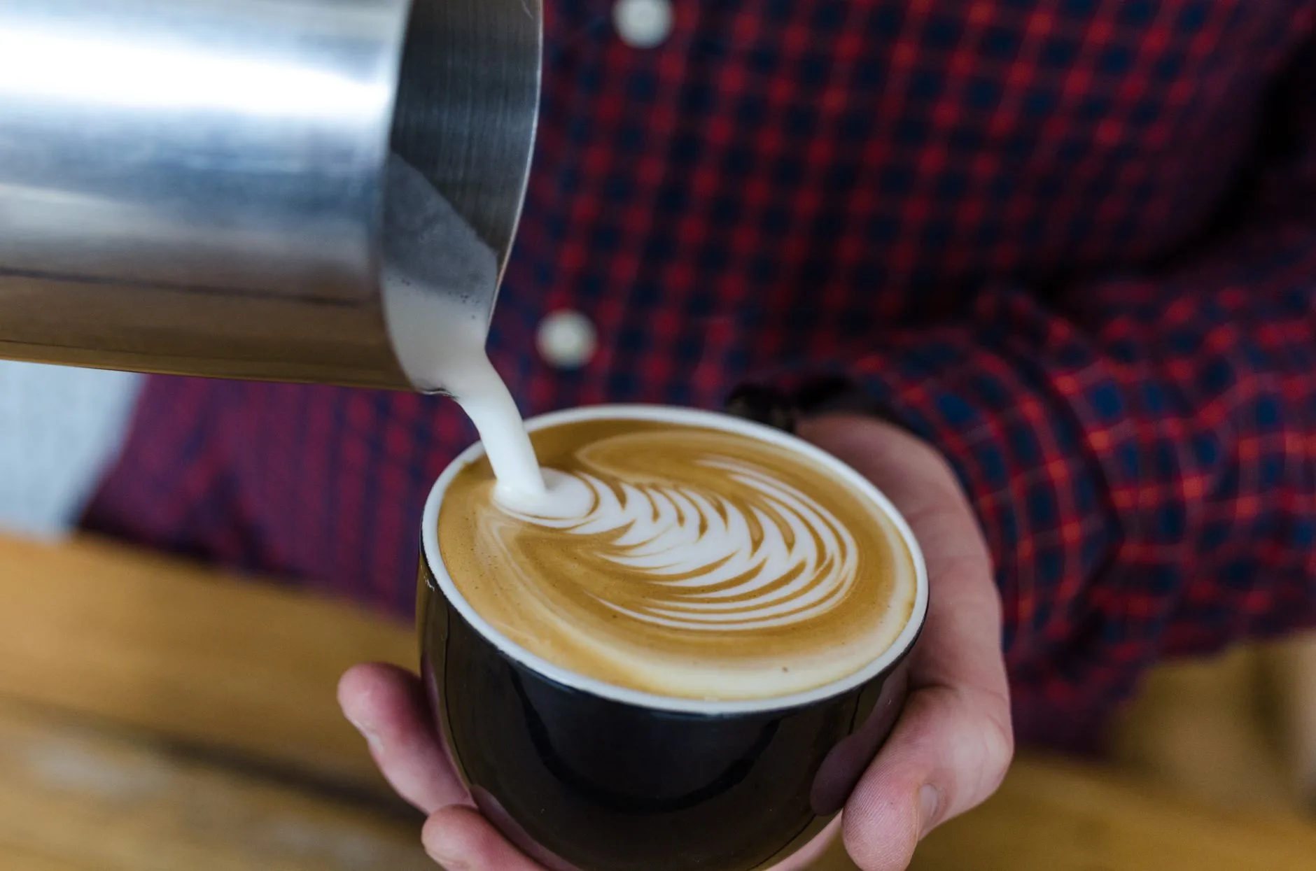Barista preparing espresso beside the roastery equipment