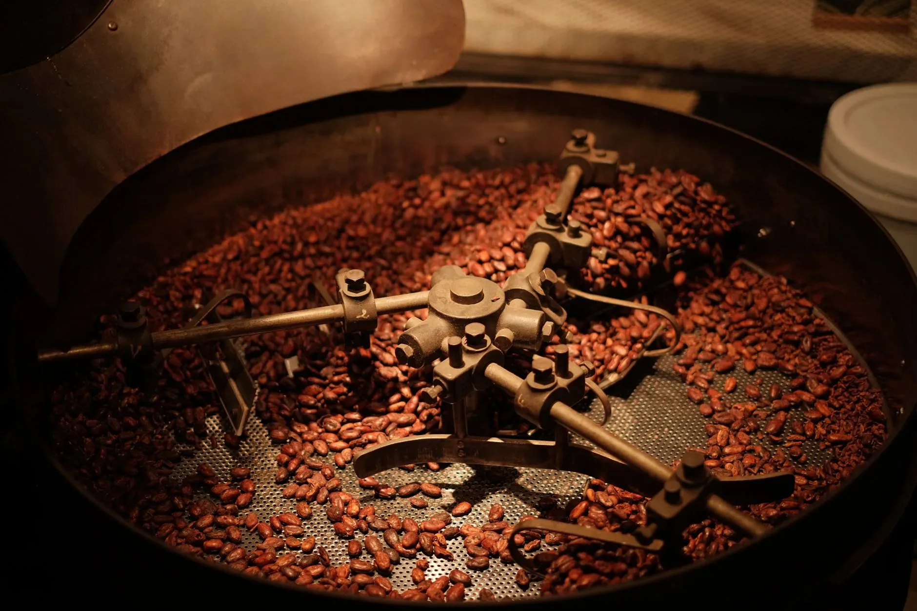 Coffee roasting process with beans, roaster drum, and warm steam in a small-batch roastery
