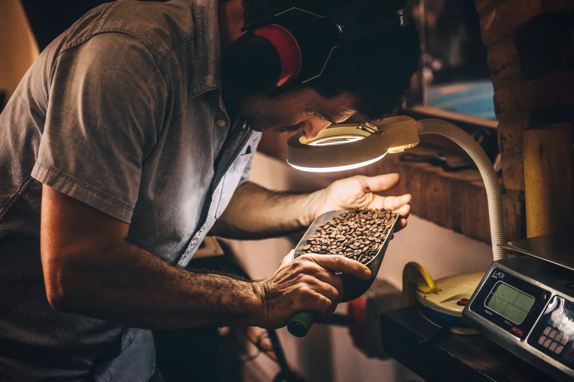 Small-batch coffee roasting room with drums, sacks, and warm industrial lighting