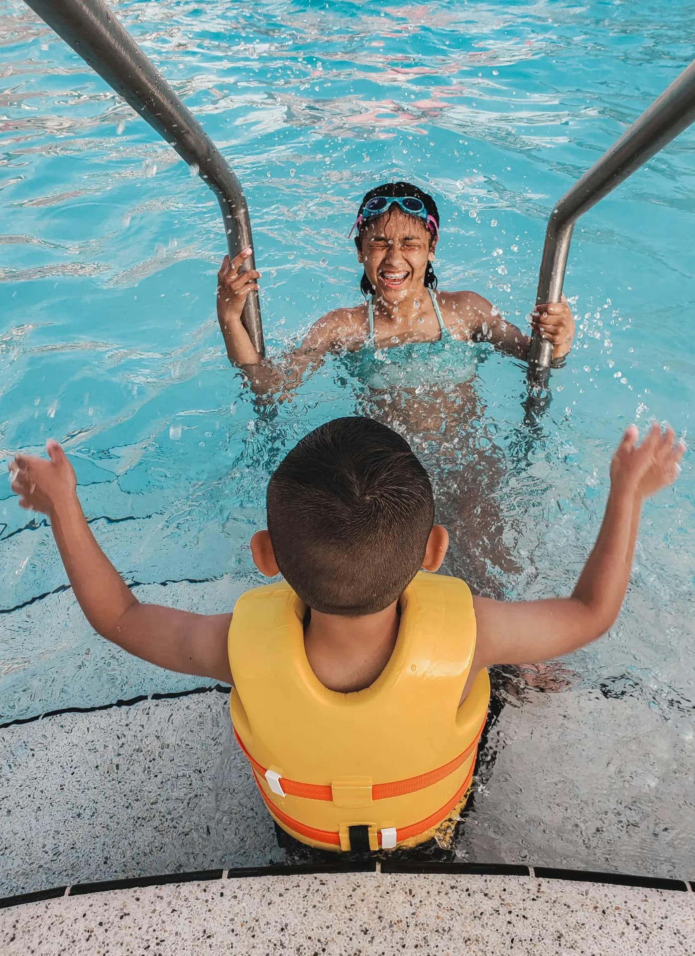 A child smiling in a swimming lesson at an indoor pool