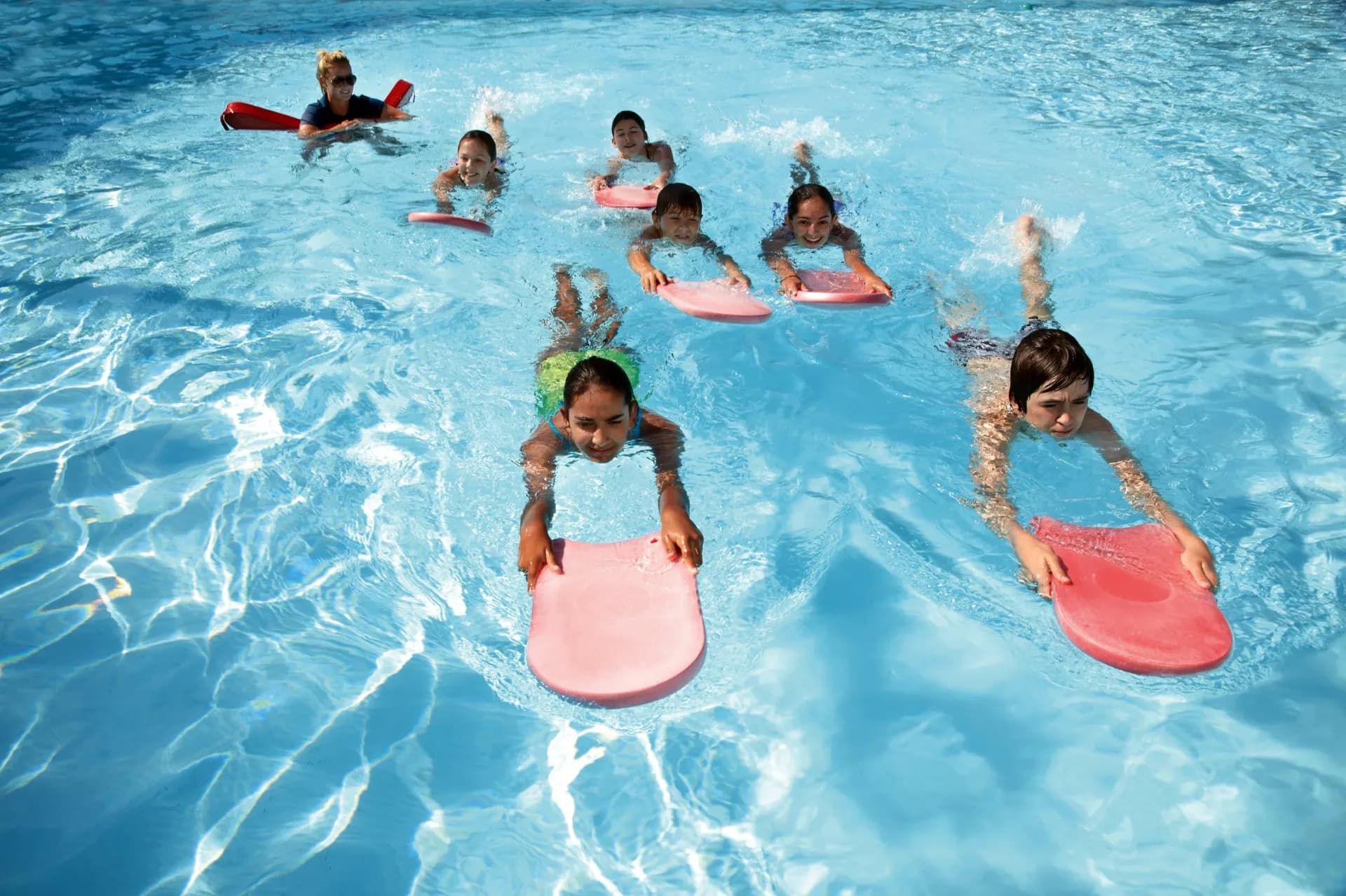 Children taking a swimming lesson in a heated indoor pool