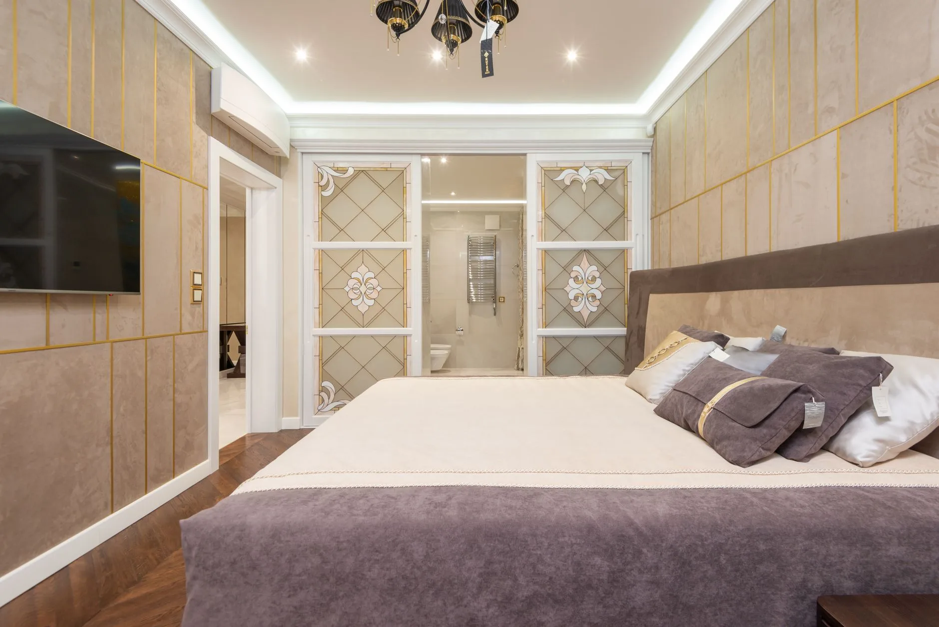 Serene master bedroom suite with linen wall panelling and statement chandelier