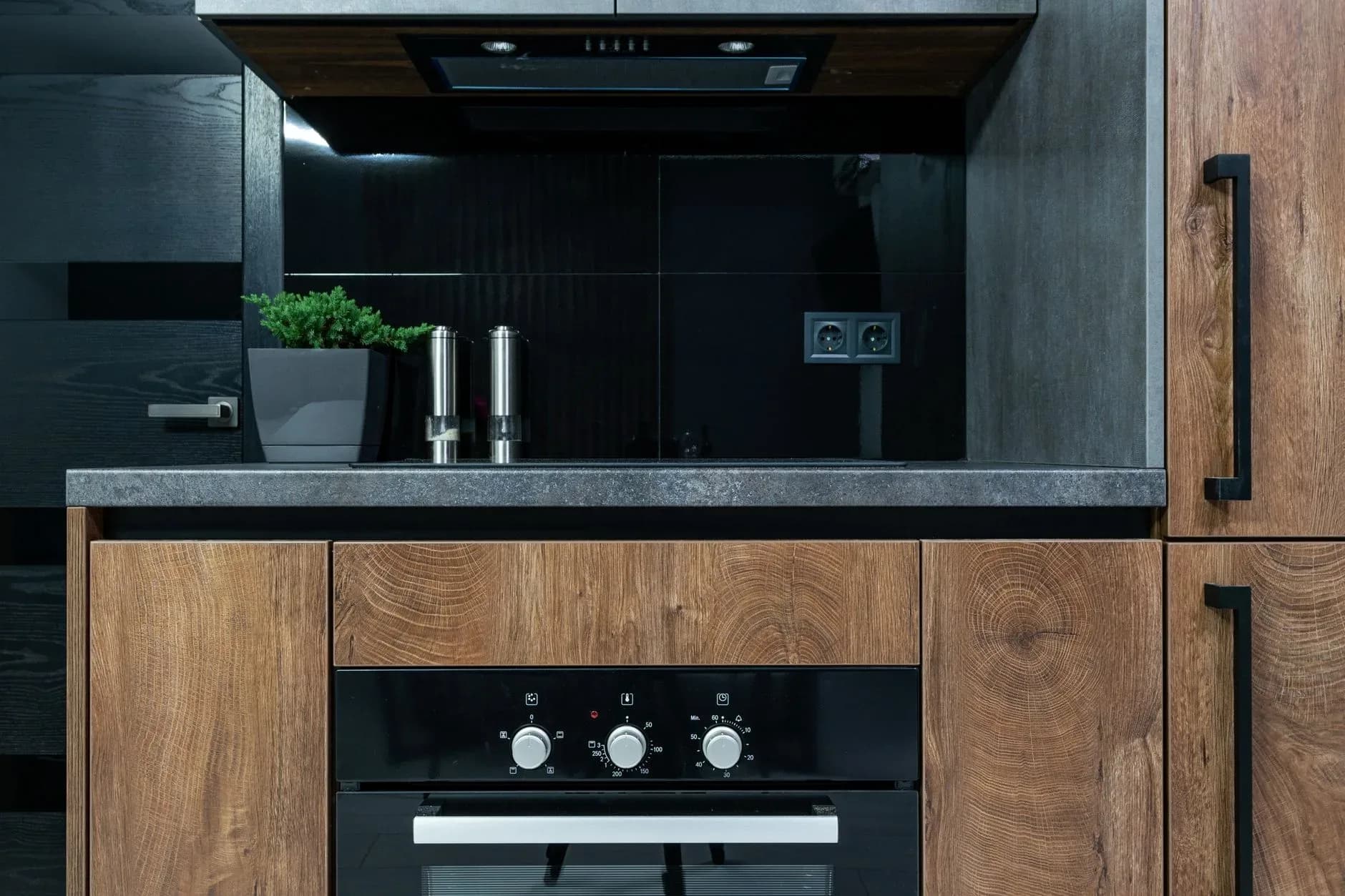 Sleek kitchen with marble island, integrated appliances and pendant lighting