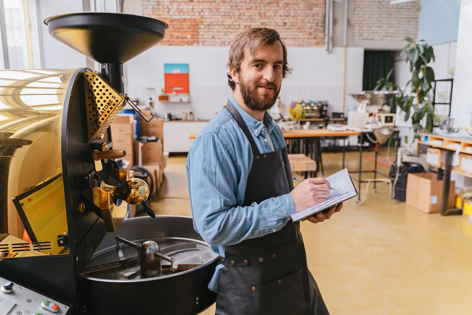 Barista in a specialty coffee roastery surrounded by roasted beans and brewing equipment