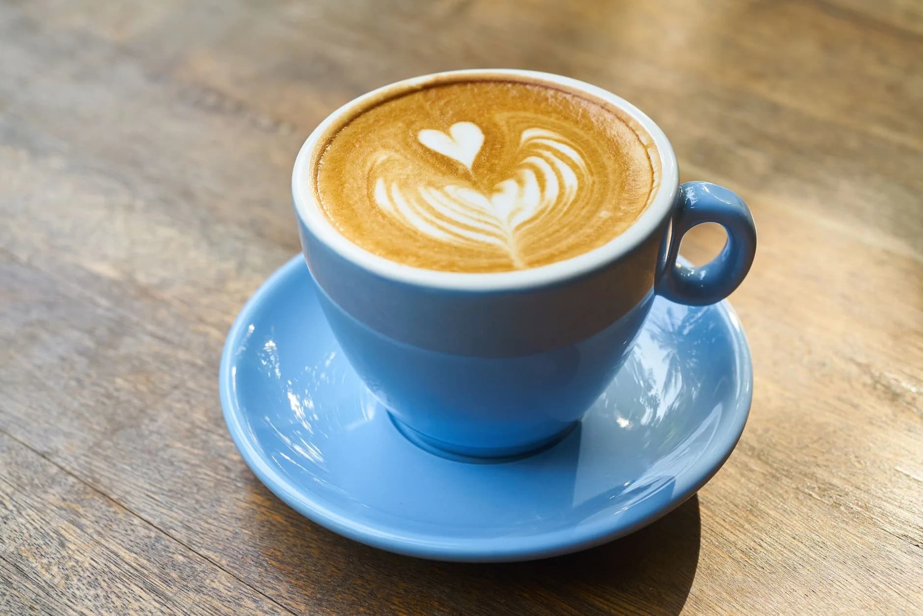 Latte art in a ceramic cup on a wooden table