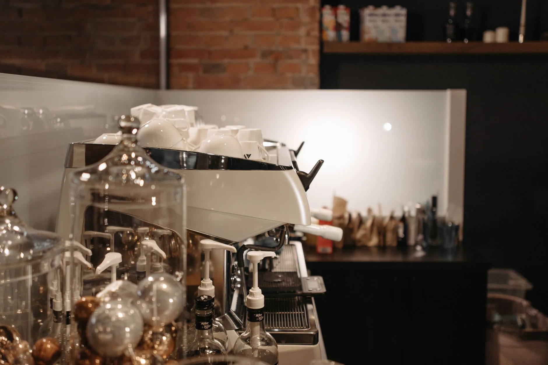 Espresso bar interior with coffee tools, cups, and warm timber surfaces