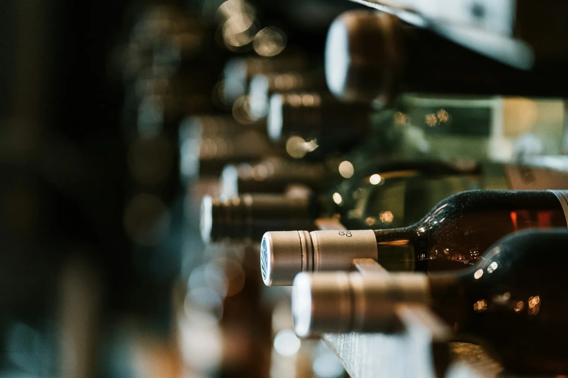 Rows of bottles in a cellar-like setting that suggest a small wine merchant's collection